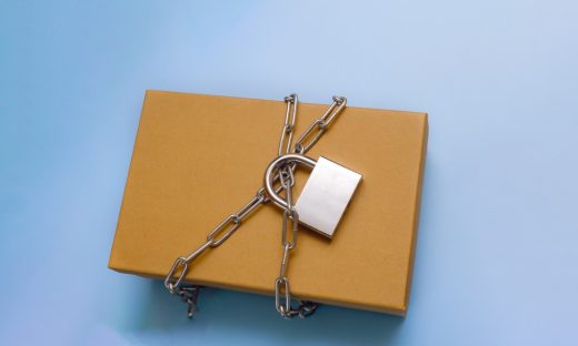 南京錠とチェーンで厳重に守られた封書（特許の非公開を象徴）