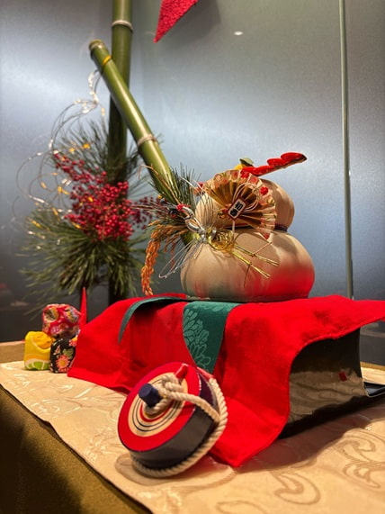 オフィスのエントランスに飾られた鏡餅、独楽、門松などのお正月飾り